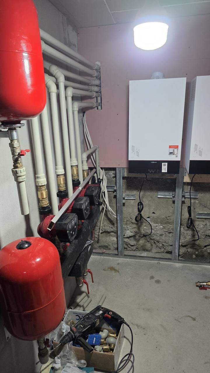 Tuberías bien alineadas sobre la pared junto a las calderas en una sala técnica