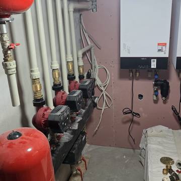 Sala técnica con calderas de pared, vaso de expansión y bombas de circulación